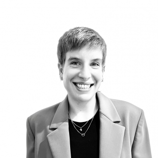 Theda Ulrike Patricia Bartolomaeus smiles in a black and white photo. Theda has short hair and a blazer.